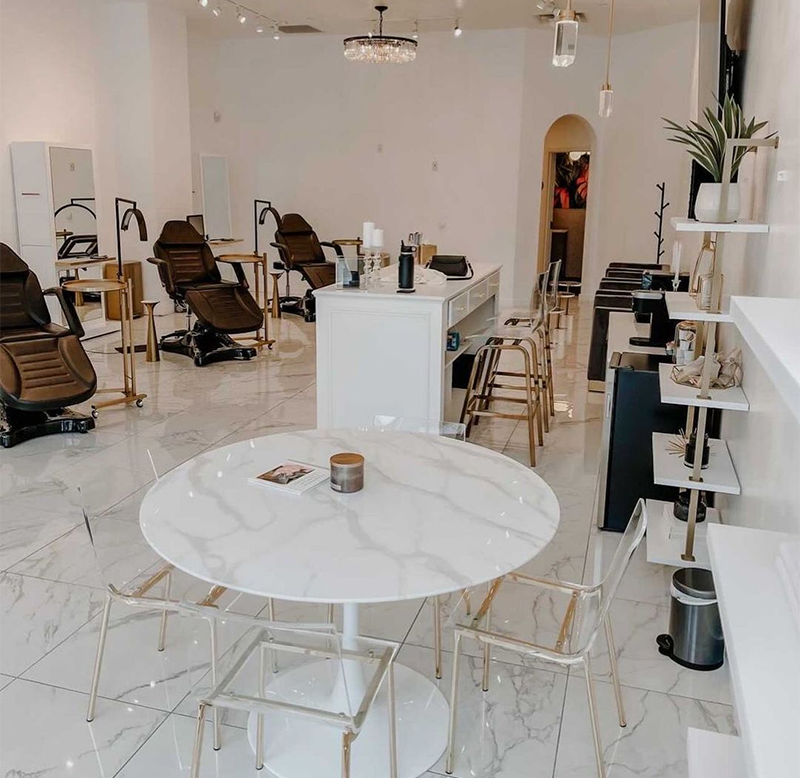 chic esthetician salon with facial chairs and LED floor lamps